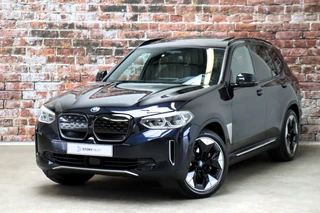 BMW iX3 High Executive 80 kWh Automaat / Driving Assistant Professional / SOH 97% / Live Cockpit Professional / Trekhaak / Panoramadak / Adaptief Onderstel / Leder / Harman Kardon / Shadow Line / Head-Up Display / Adaptieve LED-koplampen / DAB / 20 Inch